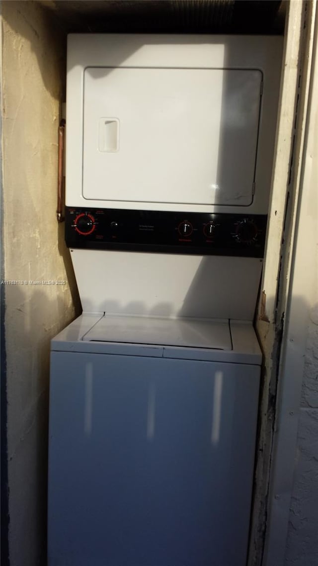 clothes washing area with stacked washer / drying machine and laundry area