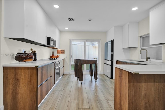 kitchen featuring a sink, stainless steel appliances, visible vents, and modern cabinets