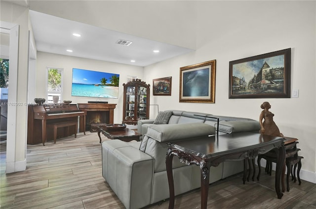 living room with visible vents, recessed lighting, and wood finished floors