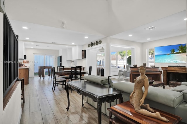 living room with visible vents, recessed lighting, and light wood-style flooring