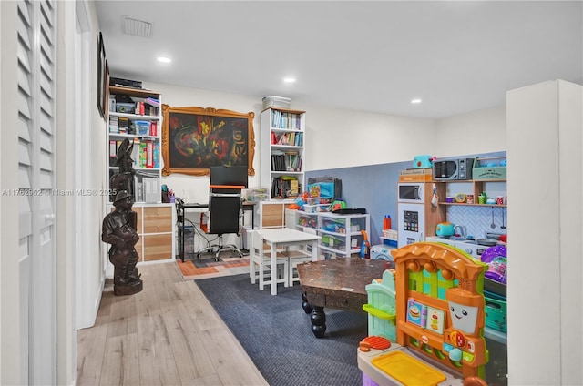 rec room with recessed lighting, visible vents, and wood finished floors