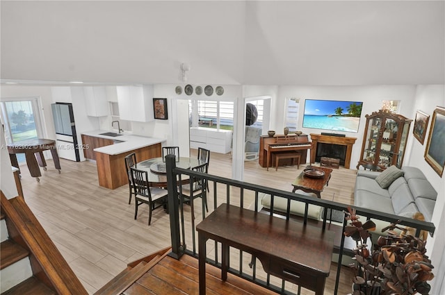 dining area featuring a healthy amount of sunlight, light wood-type flooring, and a towering ceiling