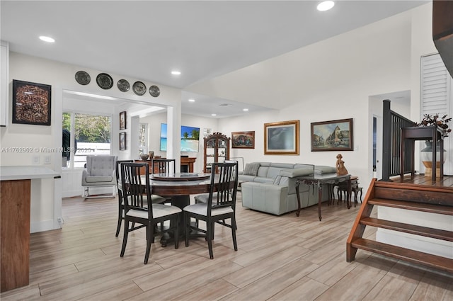 dining space featuring recessed lighting, light wood-type flooring, and stairway