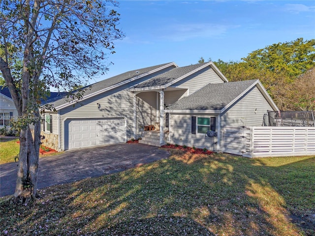 view of front of house featuring a front yard, fence, roof with shingles, an attached garage, and aphalt driveway