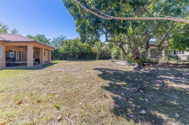 view of yard with a patio, ceiling fan, and fence