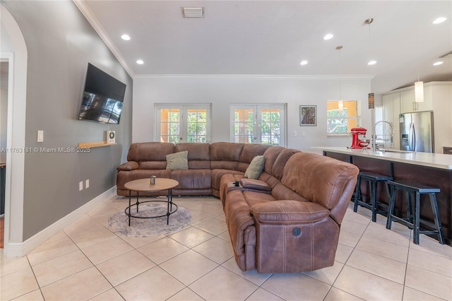 living area with light tile patterned floors, visible vents, and ornamental molding