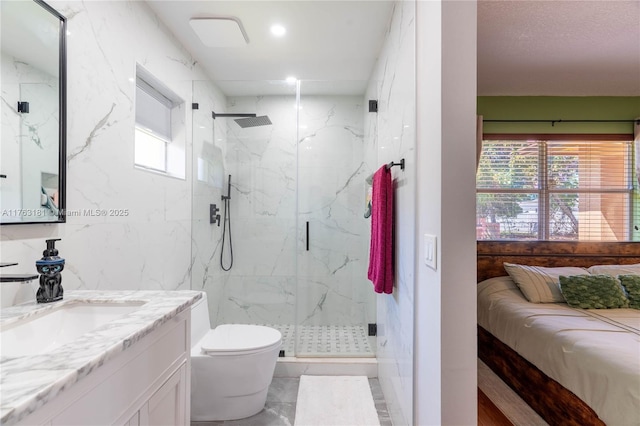 full bathroom featuring a marble finish shower, toilet, tile walls, and vanity