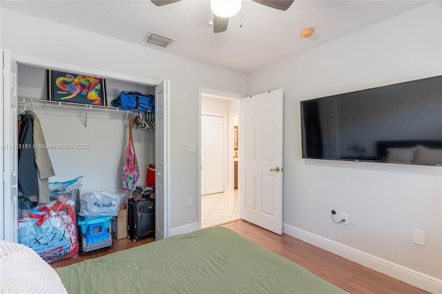 bedroom featuring visible vents, baseboards, a closet, and wood finished floors