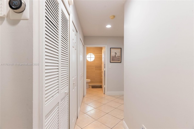 corridor featuring light tile patterned floors, recessed lighting, and baseboards