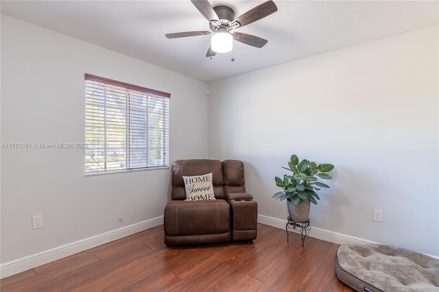 living area featuring ceiling fan, baseboards, and wood finished floors