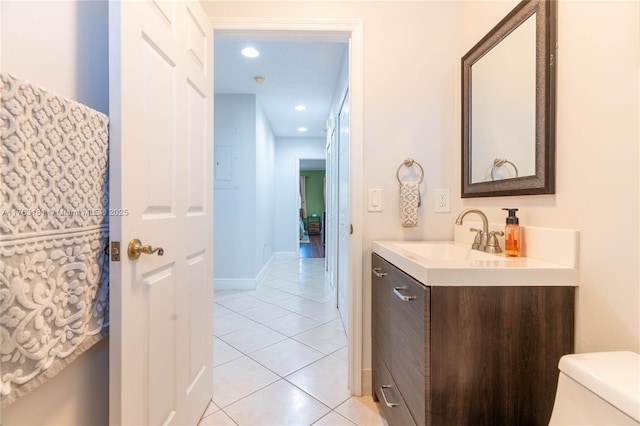 half bath with vanity, baseboards, recessed lighting, tile patterned floors, and toilet