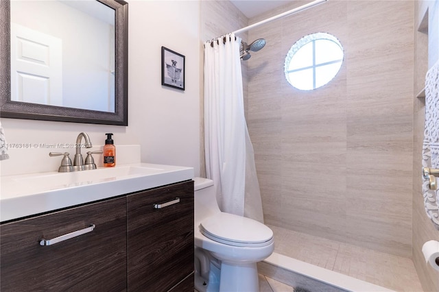 bathroom with tiled shower, toilet, and vanity