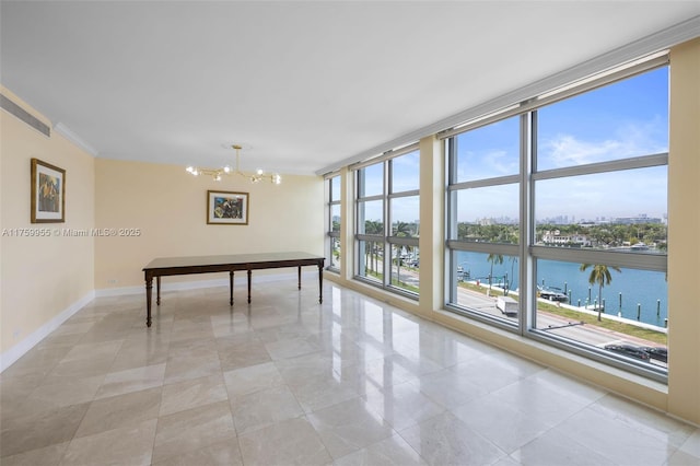 game room with baseboards, floor to ceiling windows, a water view, crown molding, and a notable chandelier