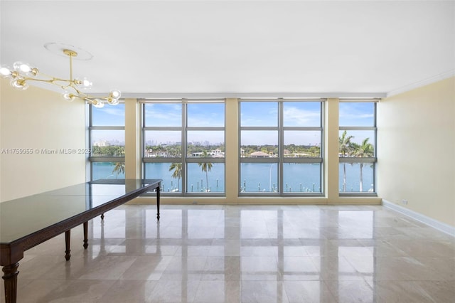 empty room featuring expansive windows, baseboards, an inviting chandelier, and a water view