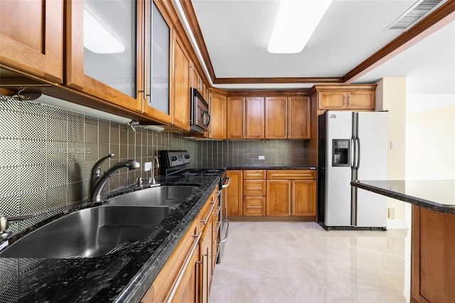 kitchen with refrigerator with ice dispenser, brown cabinetry, visible vents, and stainless steel range with electric cooktop