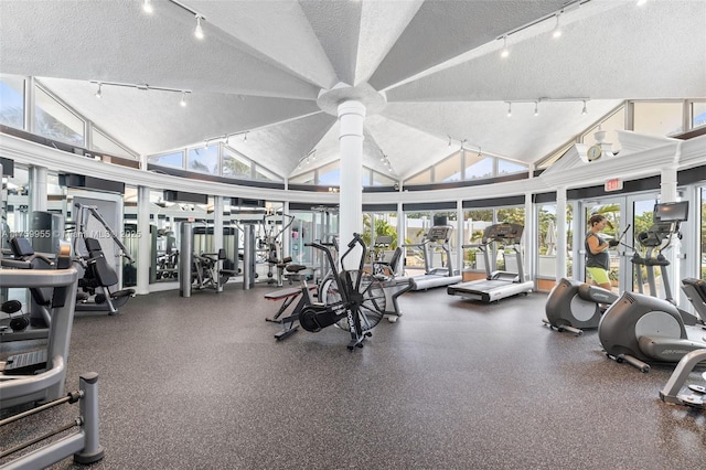 workout area featuring a textured ceiling, ceiling fan, and vaulted ceiling