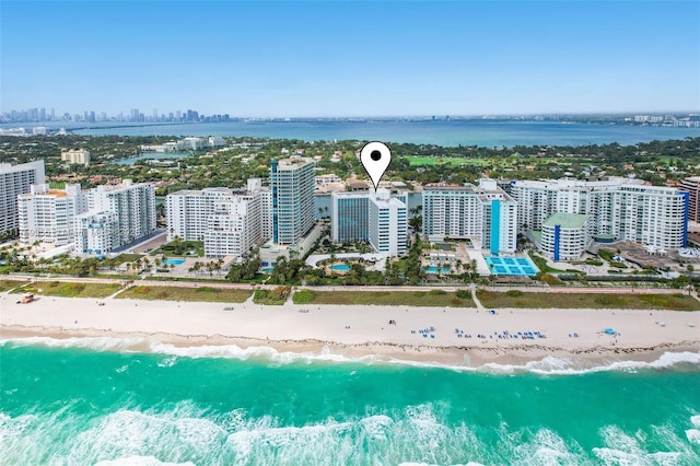 birds eye view of property featuring a view of city, a view of the beach, and a water view