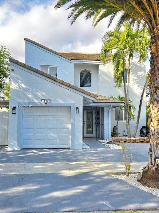 view of front facade featuring concrete driveway, an attached garage, and stucco siding