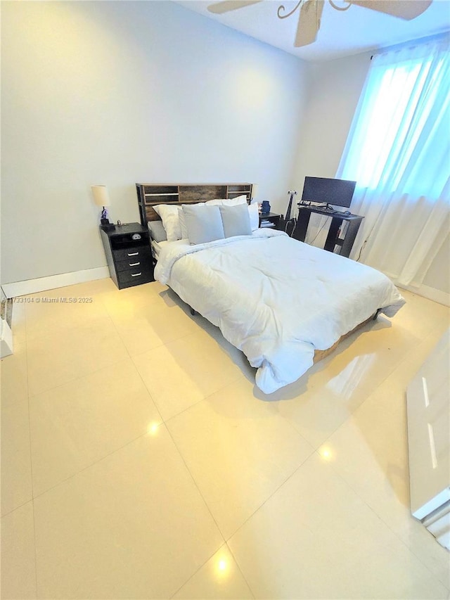 tiled bedroom featuring baseboards and ceiling fan