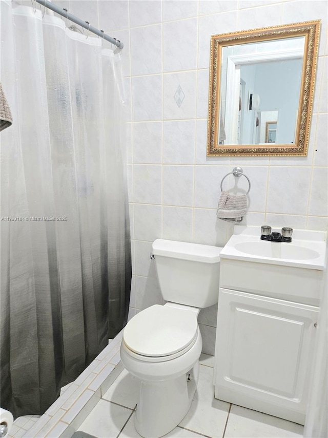 full bath with vanity, tile walls, toilet, and tile patterned floors