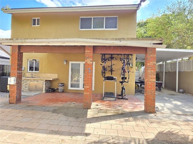 back of house with stucco siding and fence