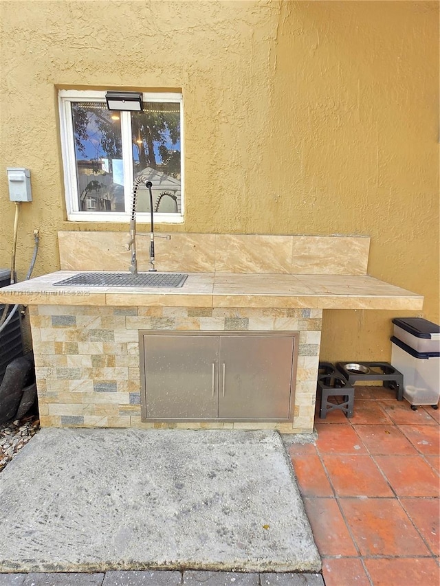 details with a sink, stucco siding, and stone siding