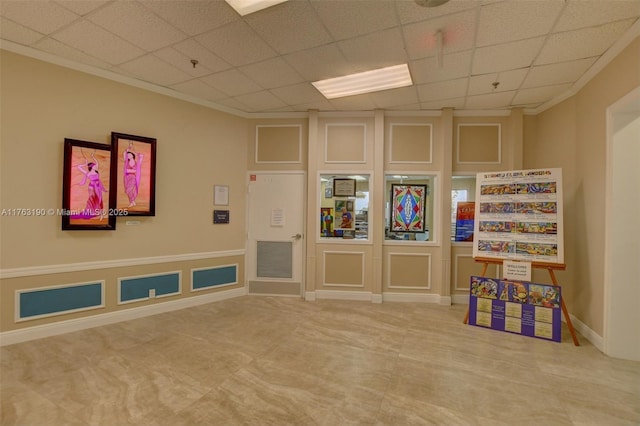 playroom with a drop ceiling, baseboards, and ornamental molding