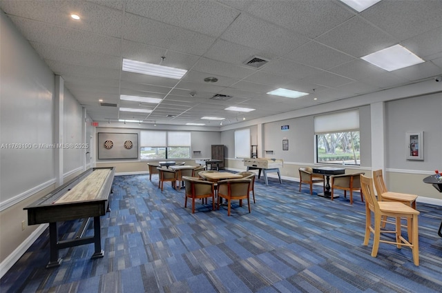 interior space featuring visible vents, dark carpet, baseboards, and a drop ceiling