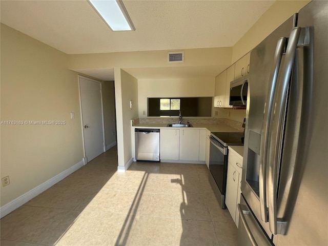 kitchen featuring a sink, stainless steel appliances, visible vents, and light tile patterned floors