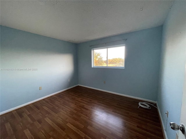 spare room with wood finished floors, baseboards, and a textured ceiling