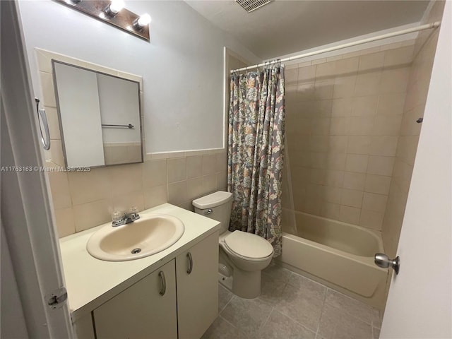 bathroom featuring toilet, tile patterned flooring, tile walls, shower / bath combination with curtain, and vanity