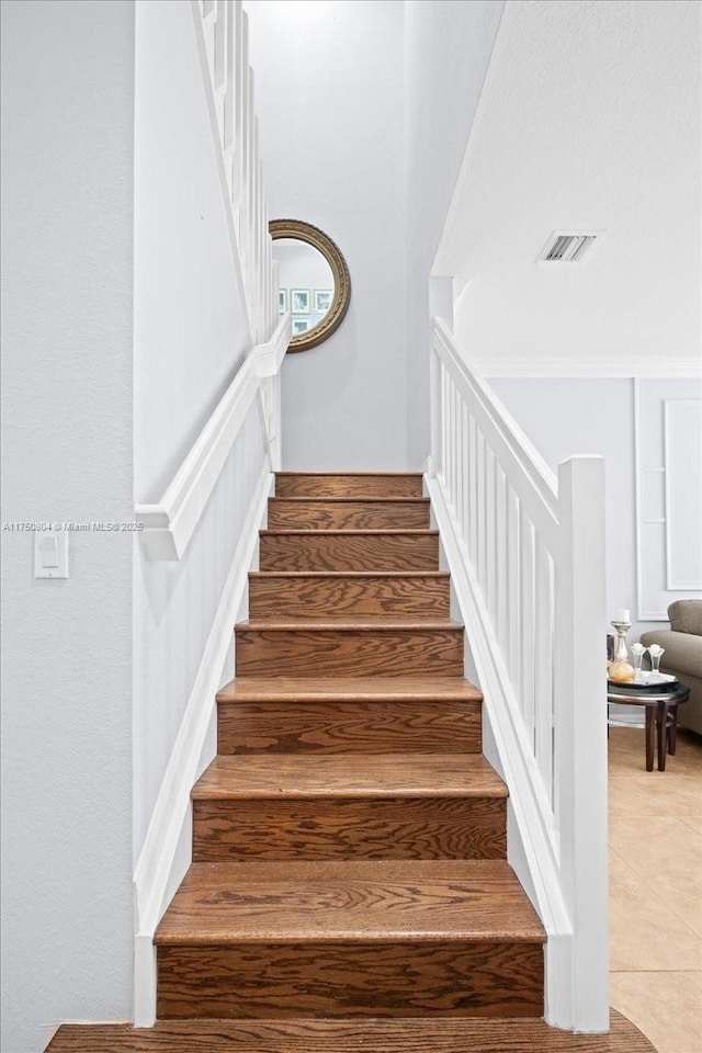 staircase with tile patterned floors and visible vents