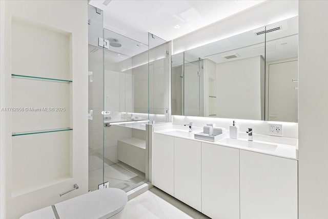 full bathroom with a shower stall, double vanity, visible vents, and a sink