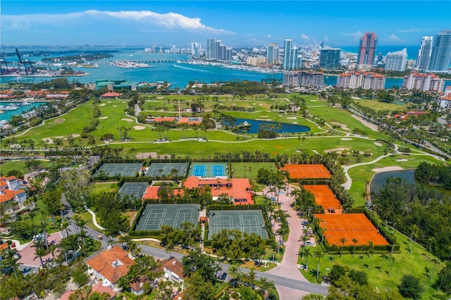 aerial view featuring golf course view, a view of city, and a water view