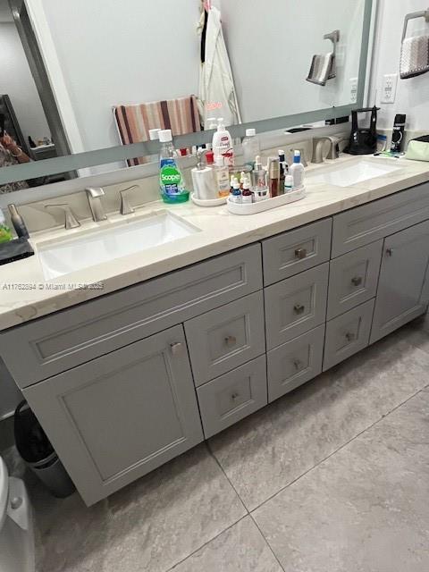 bathroom with tile patterned floors, double vanity, and a sink