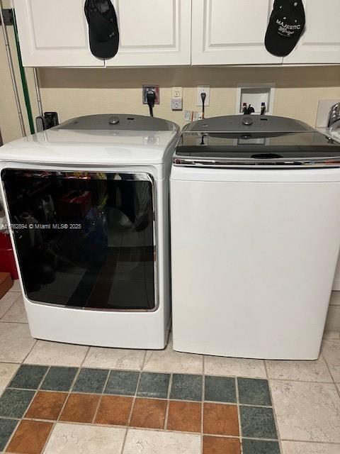 clothes washing area featuring cabinet space and independent washer and dryer