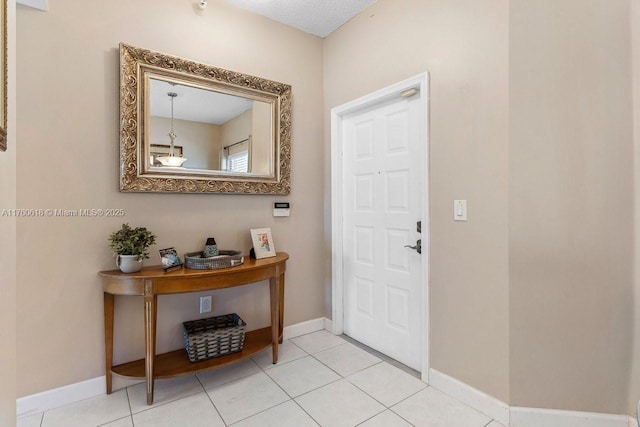 tiled foyer entrance featuring baseboards