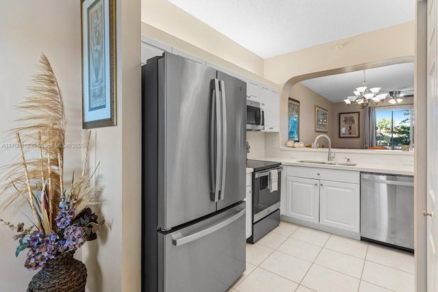 kitchen with light tile patterned floors, a sink, stainless steel appliances, light countertops, and a chandelier