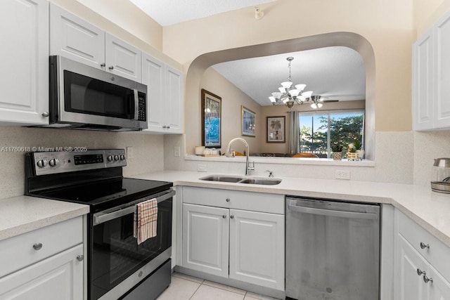 kitchen with a sink, tasteful backsplash, stainless steel appliances, light countertops, and a chandelier