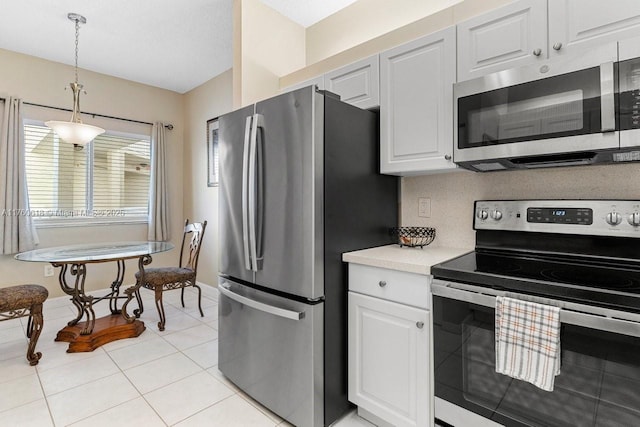 kitchen with backsplash, appliances with stainless steel finishes, light tile patterned flooring, light countertops, and hanging light fixtures