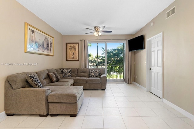 living room featuring light tile patterned floors, visible vents, baseboards, and a ceiling fan