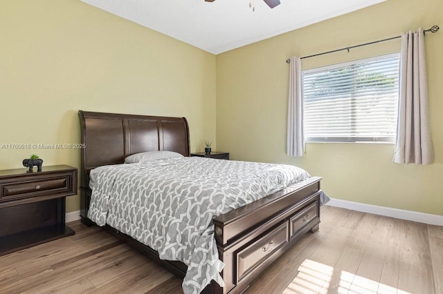 bedroom featuring baseboards, wood finished floors, and a ceiling fan