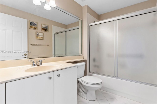 full bathroom featuring tile patterned flooring, toilet, vanity, and bath / shower combo with glass door