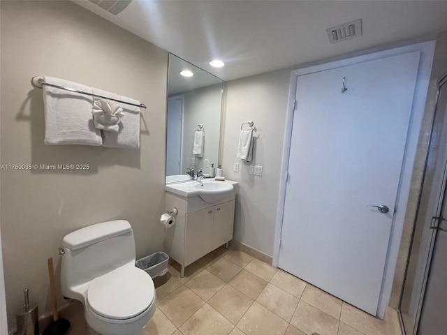 bathroom featuring vanity, baseboards, visible vents, tile patterned flooring, and toilet