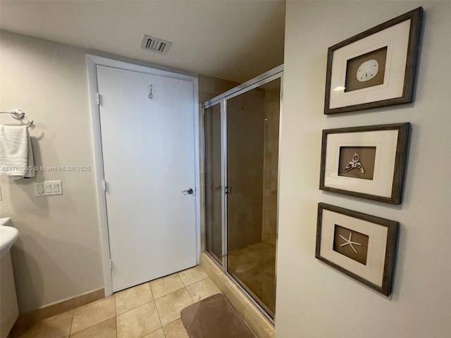 full bathroom featuring tile patterned flooring, visible vents, a shower stall, and baseboards