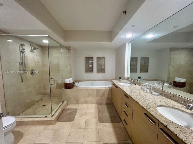 bathroom featuring a stall shower, toilet, a garden tub, and a sink