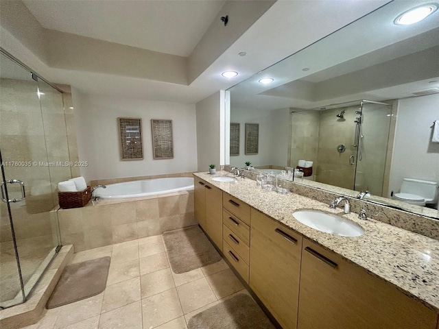 bathroom featuring a shower stall, a garden tub, a raised ceiling, and a sink