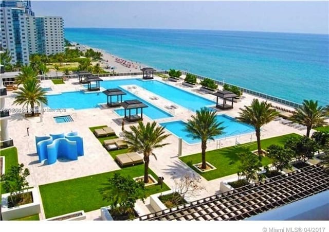 pool with a patio area and a water view