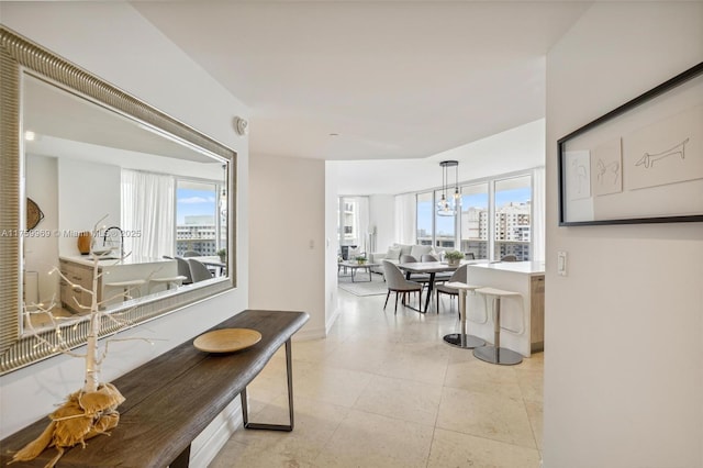 hallway with a wealth of natural light, a city view, and light tile patterned floors