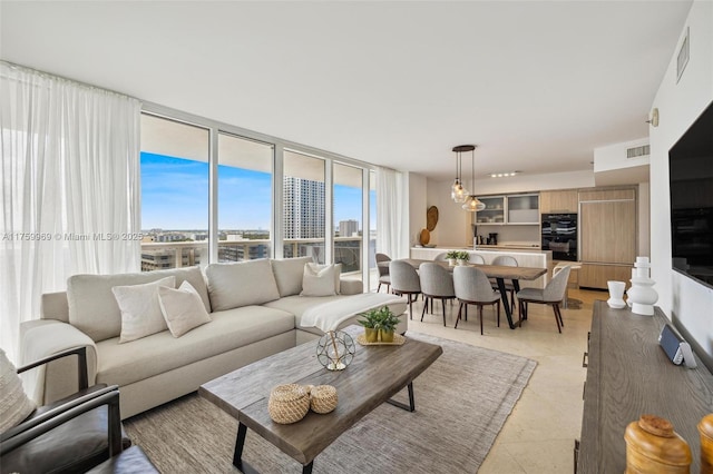 living area featuring visible vents, floor to ceiling windows, and a city view